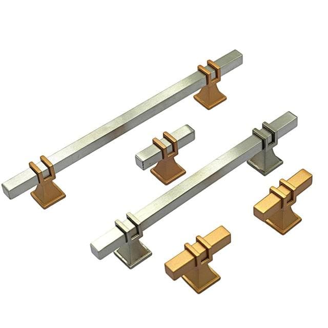 Two-tone bar pulls and gold knobs on a white surface